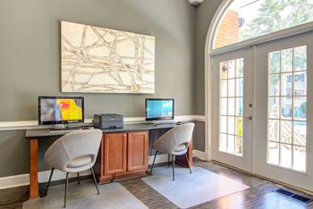 a home office with two computers and two chairs